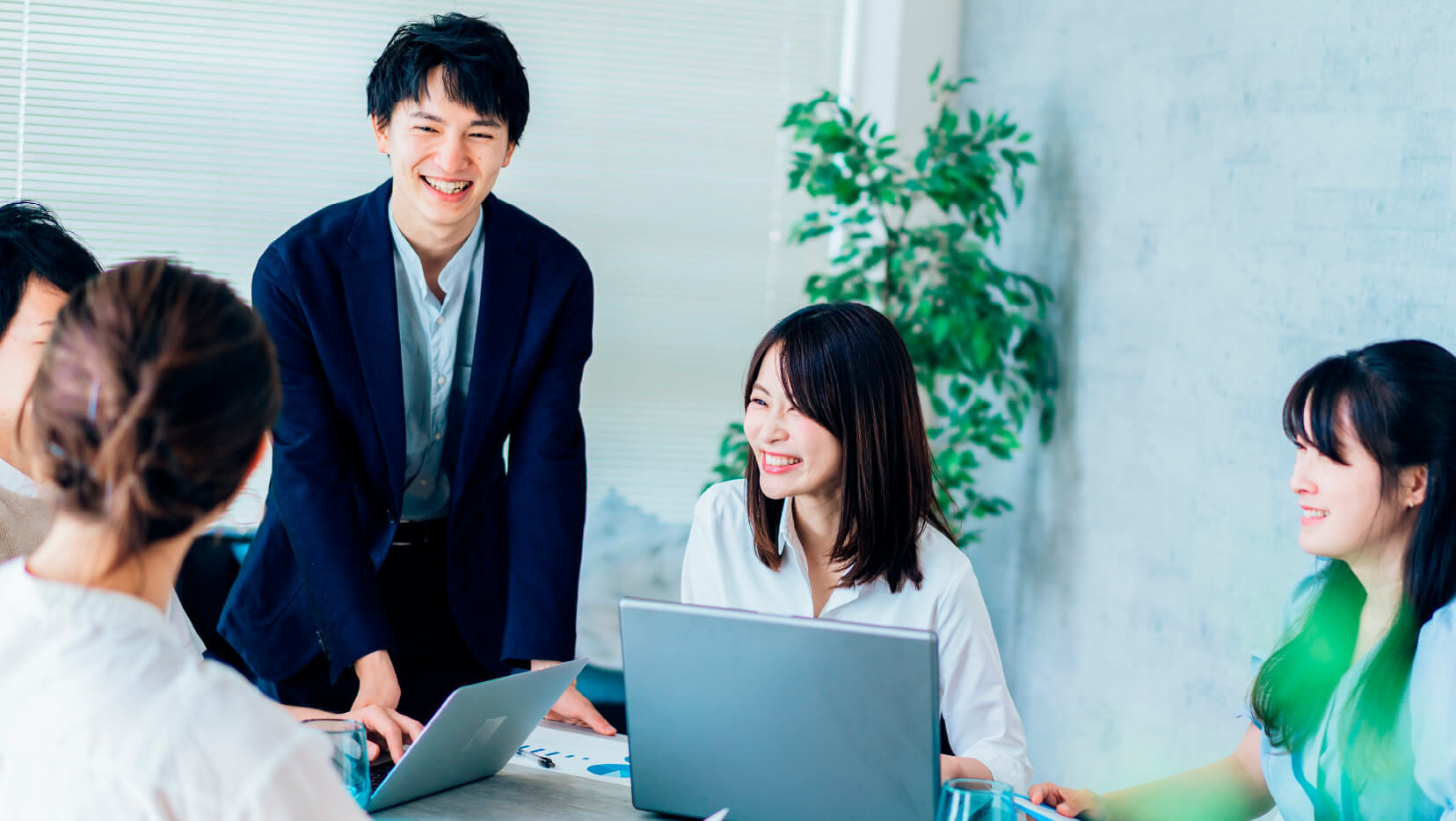 オフィスで笑顔で会話をしながら楽しむ従業員たち